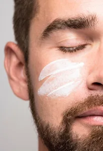 Cream on man’s cheeks closeup shot