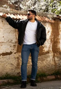 man in black puffy jacket standing near wall