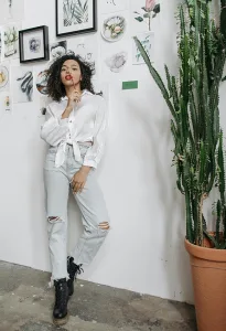 woman wearing white satin top and blue jeans