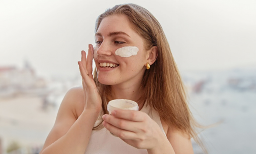 Woman applying moisturizer