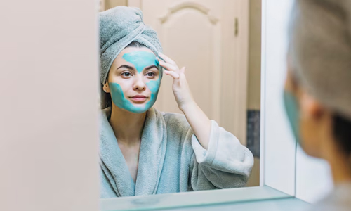 Woman applying blue facemask