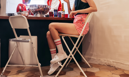 Women wearing red mini skirt and white sneakers