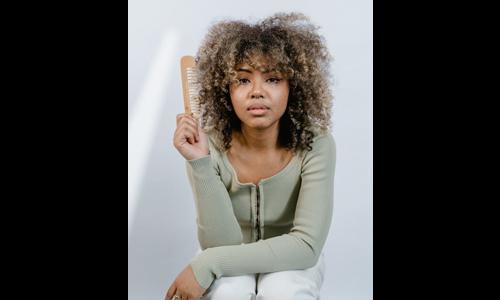 Curly hair women with a comb in hand