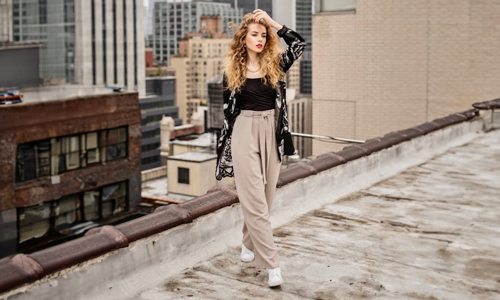 Woman wearing black overcoat and beige trousers