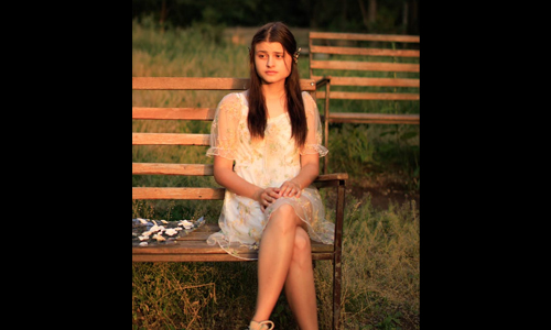 women in white dress sitting in bench