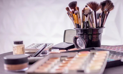 Makeup products and brush in table
