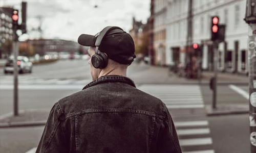 Man-wearing-headphones-on-hat