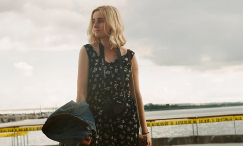 Woman holding denim jacket in hand