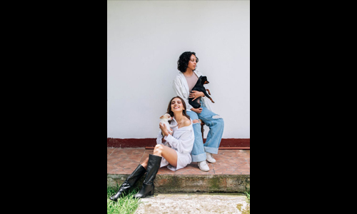 Two women in white shirt with dogs