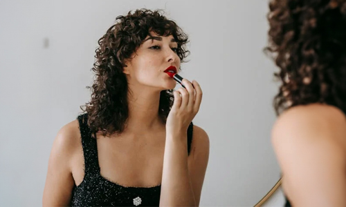 Woman applying red lipstick