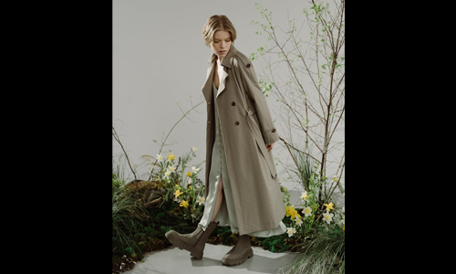 Woman wearing long checkered coat and boots