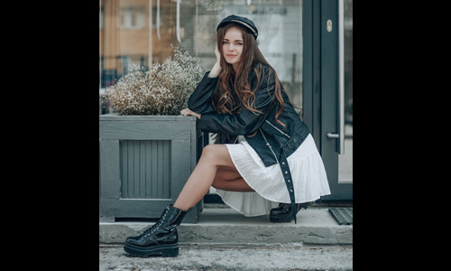 Woman wearing white skirt and black leather jacket