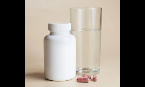 Glass of water and capsules