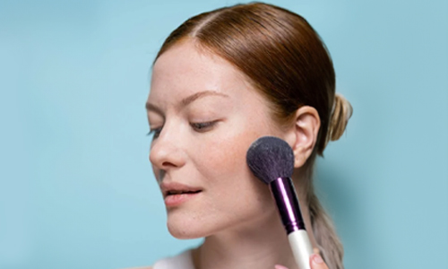 Woman applying blush