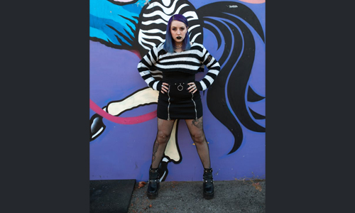 Woman standing against painted wall