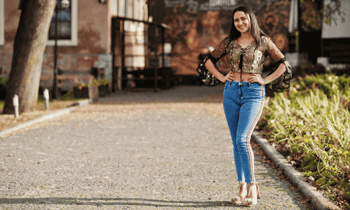 Young woman in a stylish jeans outfit posing outdoors, showcasing a casual first date look for women.