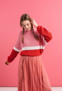 Young woman in layered, vintage-style outfit, showcasing the messy girl look.