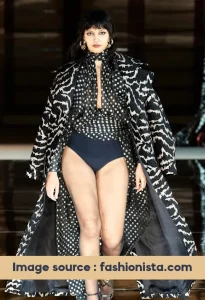 women in runway wearing polka dot top and long coat