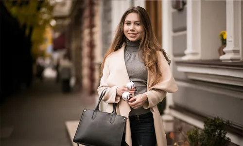 Woman confidently carrying a handbag standing outdoors
