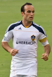 Landon Donovan smiling during a public appearance with a neatly styled hairstyle