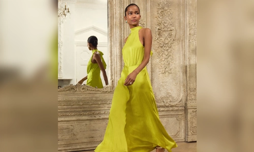 Woman wearing a lime green maxi dress styled with nude strappy heels