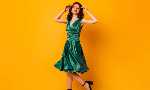 Woman wearing a satin green dress styled with black high heels