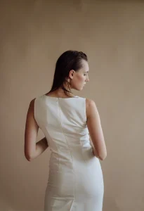 Woman zipping up a fitted dress by herself using a back zipper